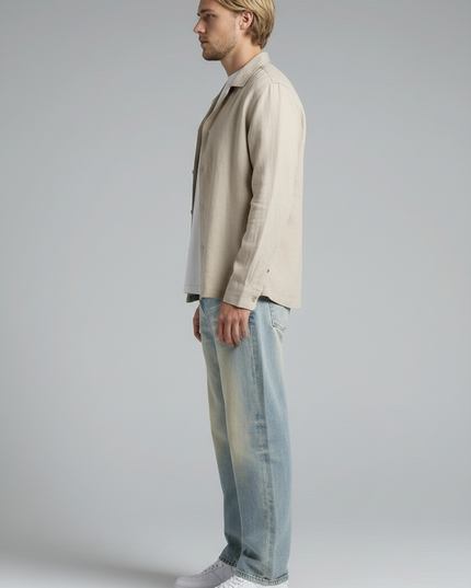 Side profile of the model wearing NWRLD 003 / Sun Fade Raw Hem Denim Jeans