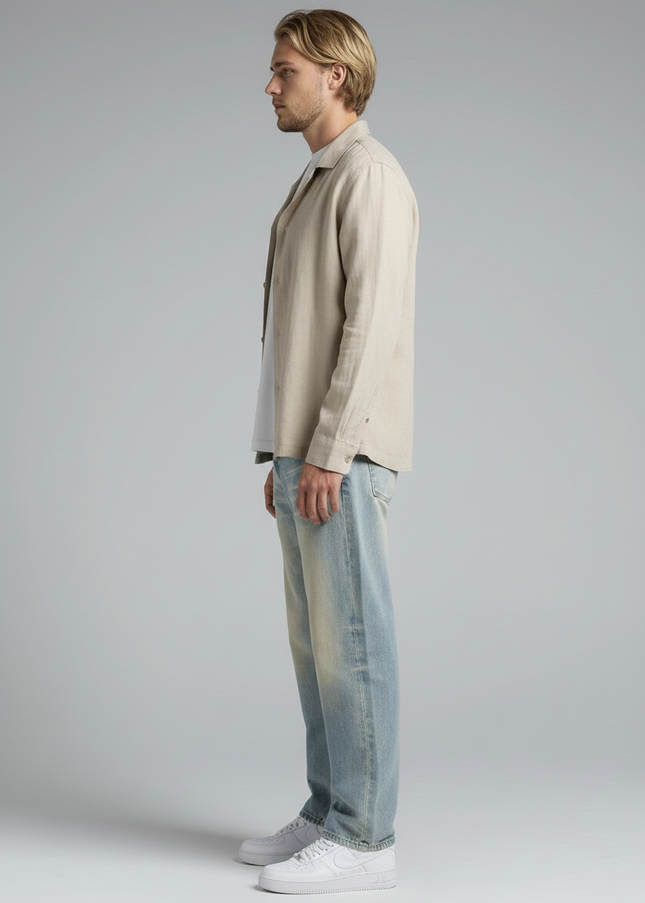 Side profile of the model wearing NWRLD 003 / Sun Fade Raw Hem Denim Jeans