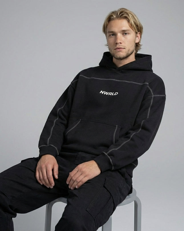 Model sitting while wearing Contrast-Stitched Boxy Fleece Hoodie