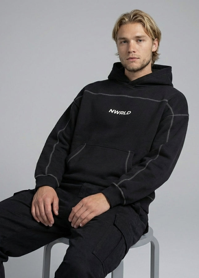 Model sitting while wearing Contrast-Stitched Boxy Fleece Hoodie
