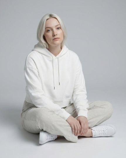 Model sitting while wearing Essential Cropped Hoodie