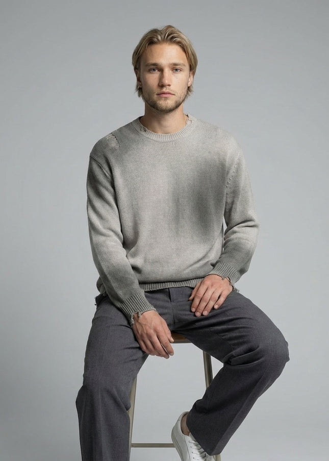 Model sitting while wearing Sun Fade Distressed Ripped Crewneck sweater